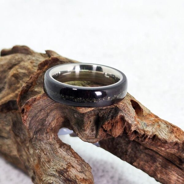 African Blackwood Stainless Steel ring with a Pyrite Inlay resting on a piece of wood